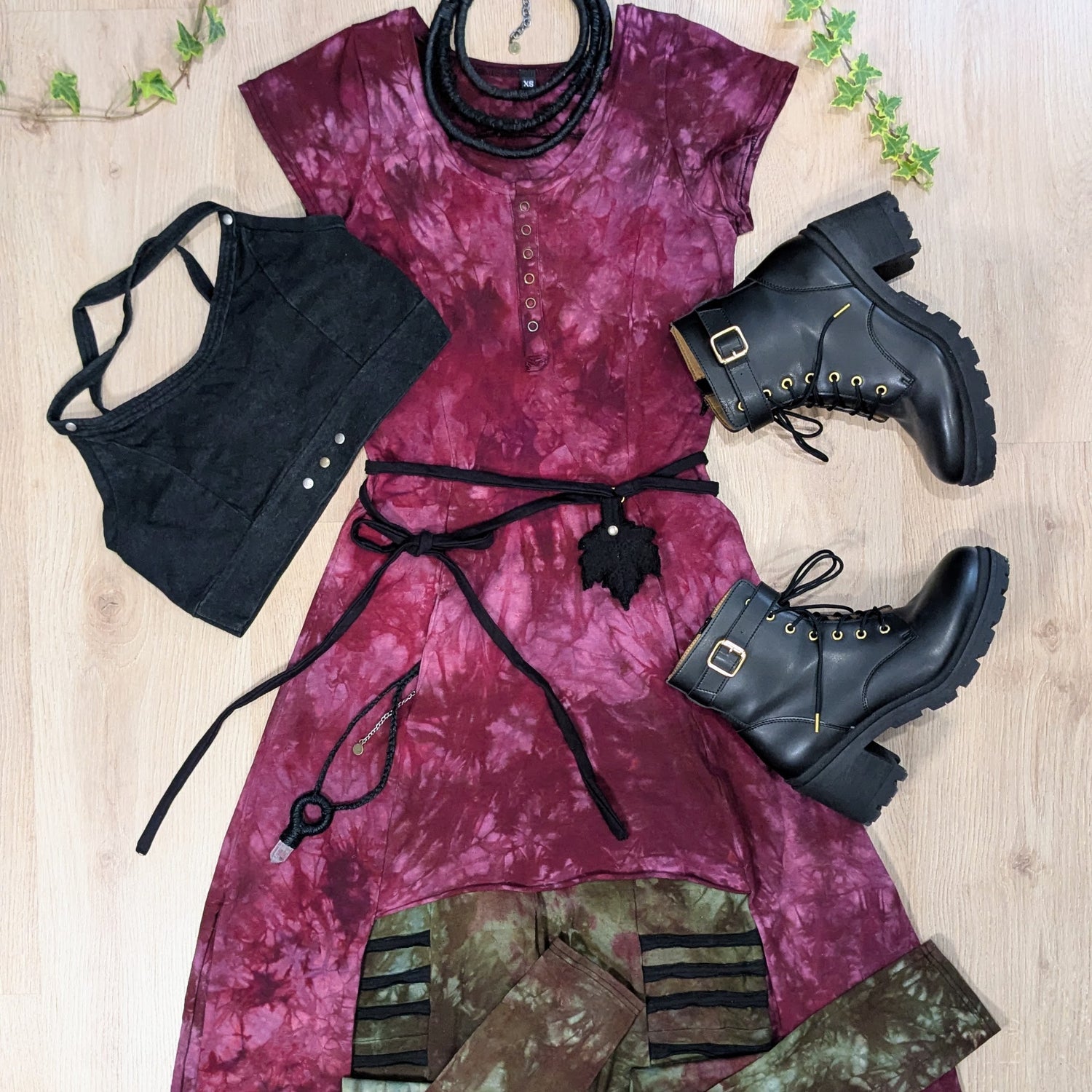 Purple tie-dye outfit with black boots and quartz pendant on a wooden surface